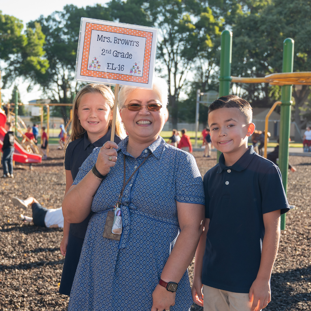 Elementary teacher welcomes two students on the first day of school at Vacaville Christian School.