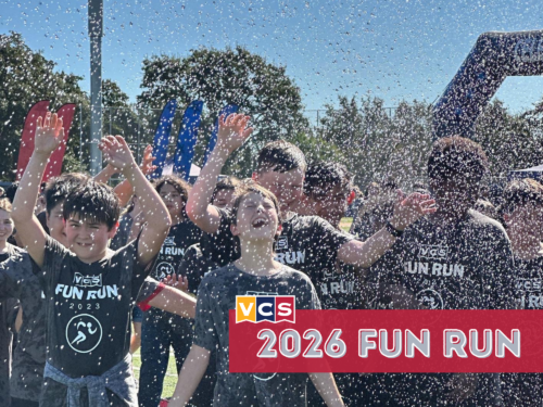 VCS students participating in the Falcon Fun Run, with water spraying as they run and celebrate together.