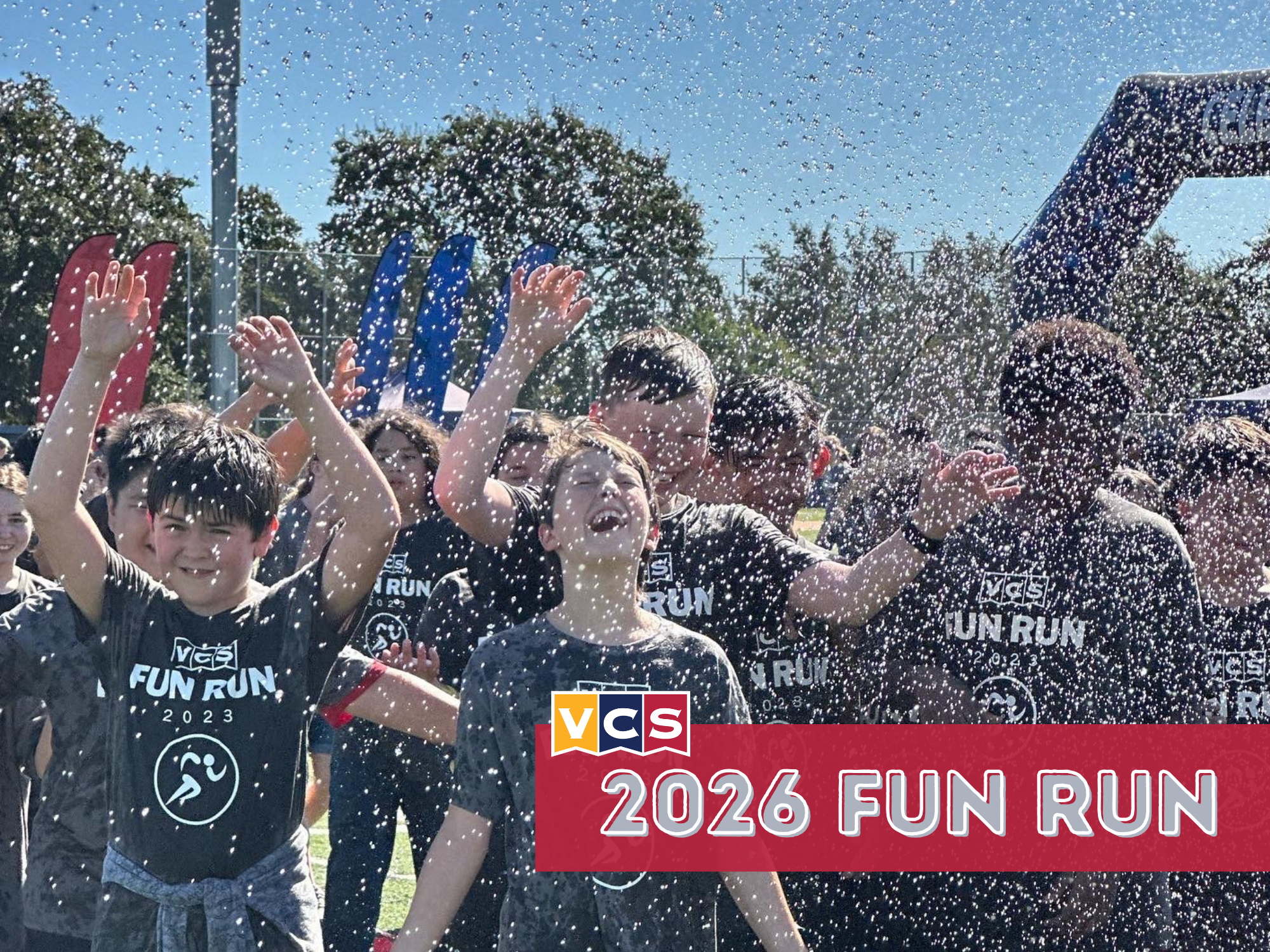 VCS students participating in the Falcon Fun Run, with water spraying as they run and celebrate together.